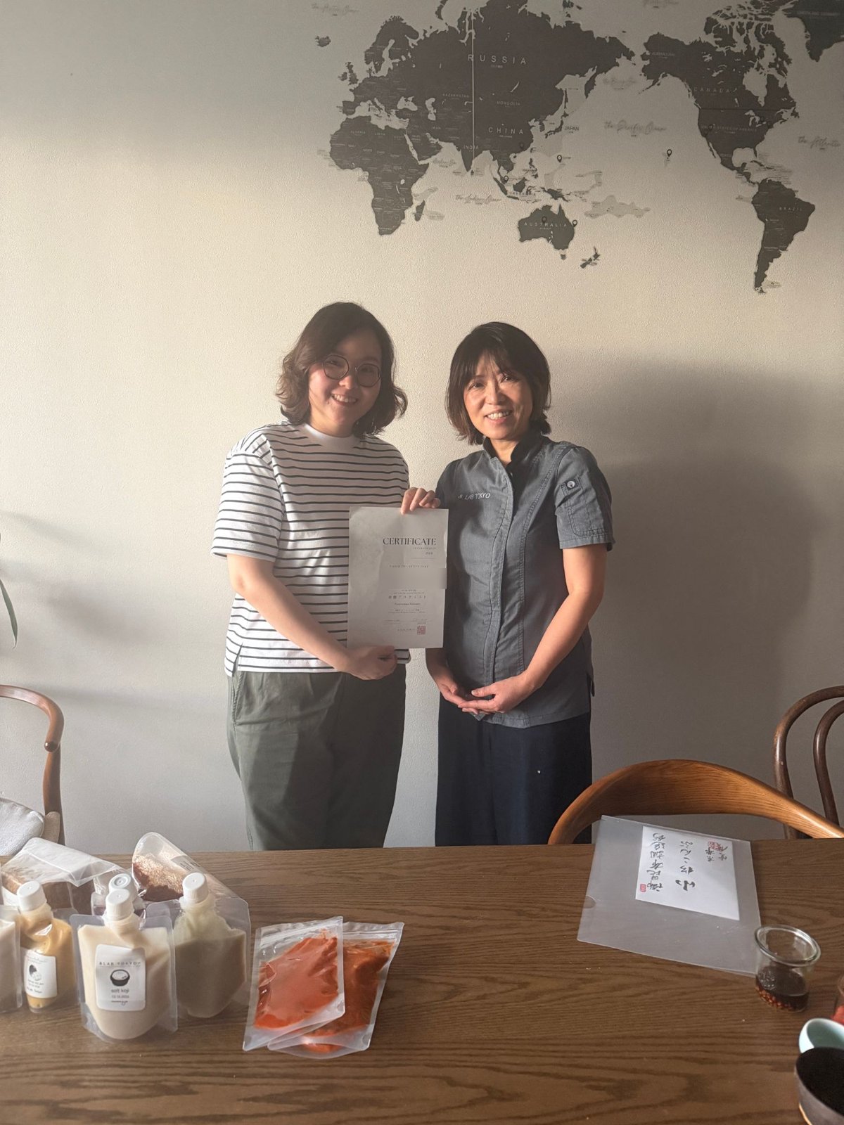 修了証を手にしたタイの Joy さんと安藤千英（東京・神宮前の &LAB TOKYO で）