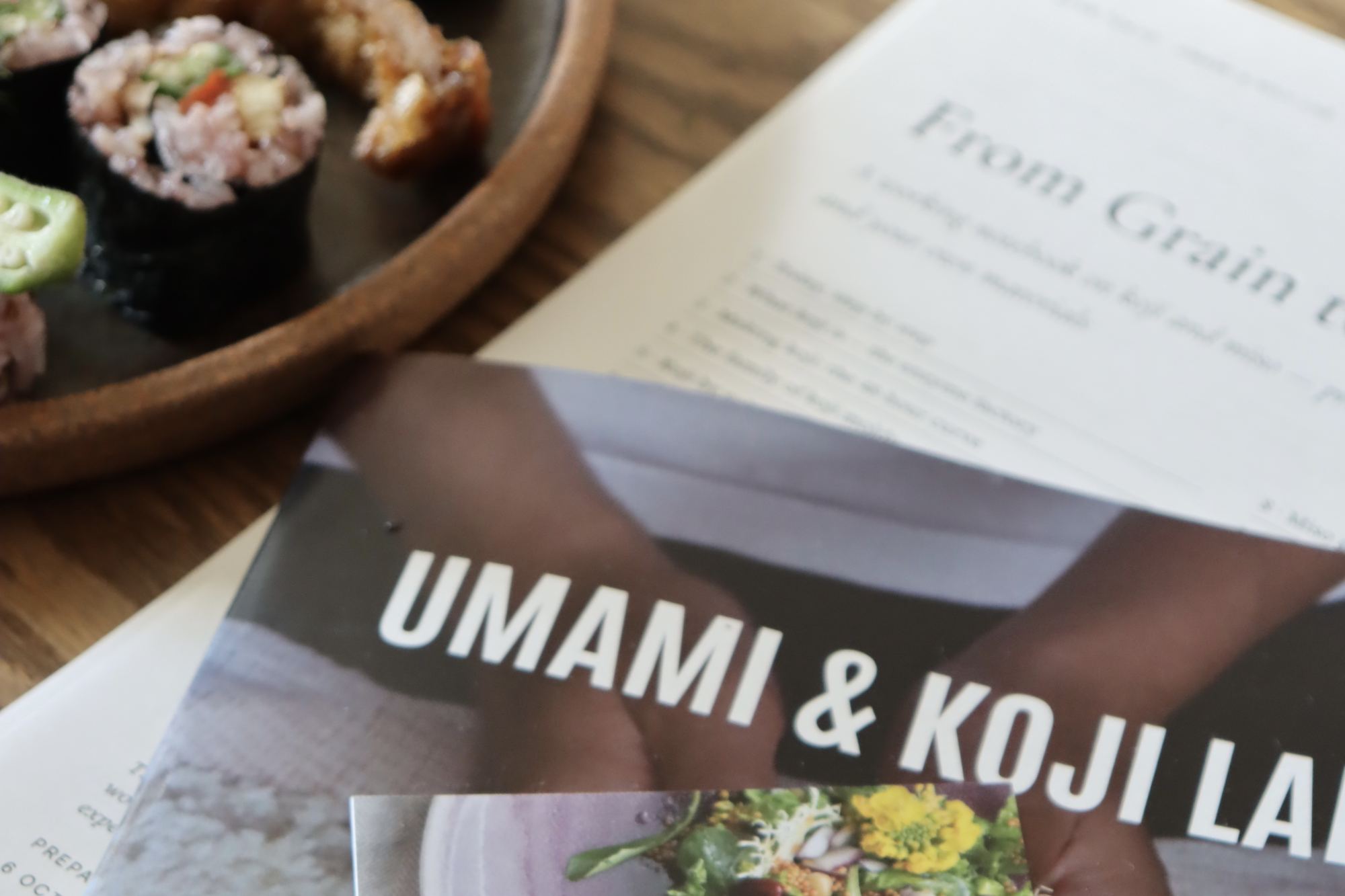 桌上放着 UMAMI & KOJI LAB 的教材，以及为这次课程特别制作的补充手册