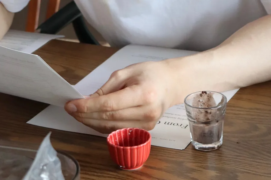 テキストを手に、試食の器を前にした Ryan さん（UMAMI & KOJI LAB）